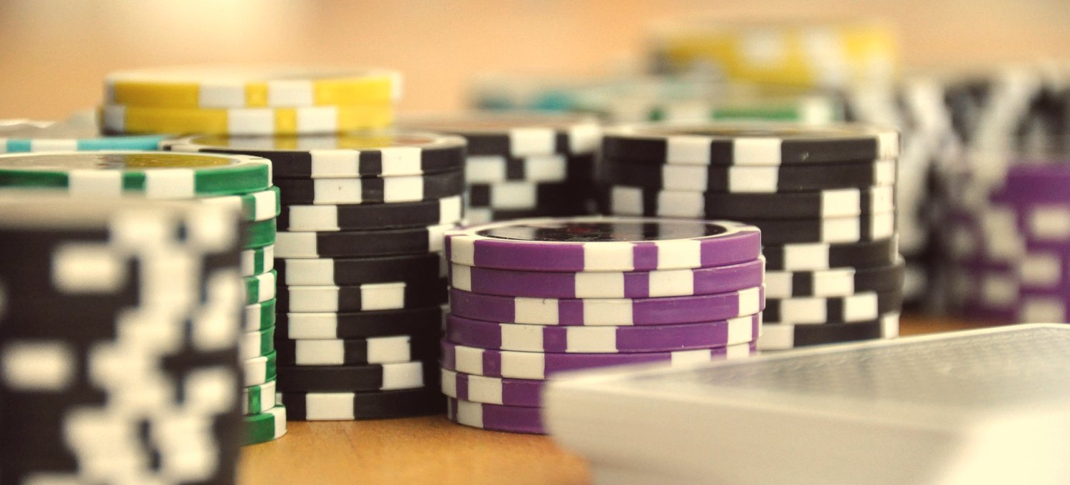 Vintage poker chips and playing cards on green felt, warm light